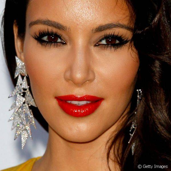 Kim Kardashian ousou ao fazer o contraste do tom da roupa com os lábios preenchidos por gloss vermelho vibrante durante o baile da amFAR em Cannes 2012 